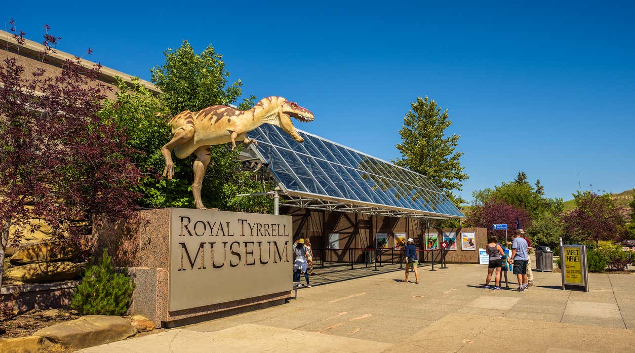 Drumheller, Alberta: Visitors at the front entrance of the Royal Tyrrell Museum of Palaeontology in Alberta with a dinosaur sculpture in the foreground