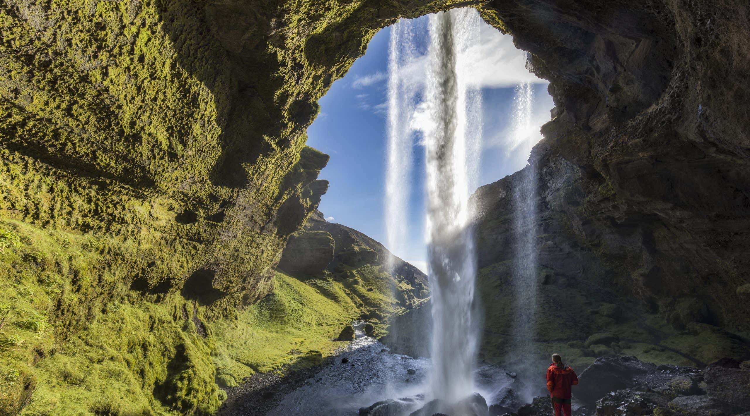 Hiker at Majestic Kvernufoss Waterfall in Iceland