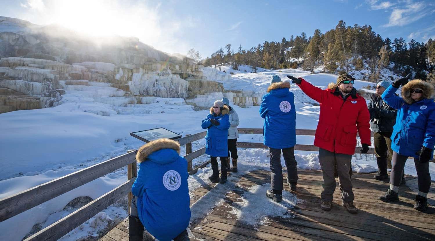 Guests from a Natural Habitat trip in Yellowstone admiring view of geology in park.