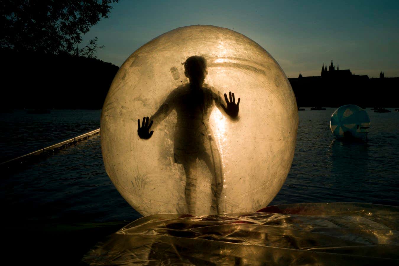A tourist enjoys a zorb ball on the Vltava river.